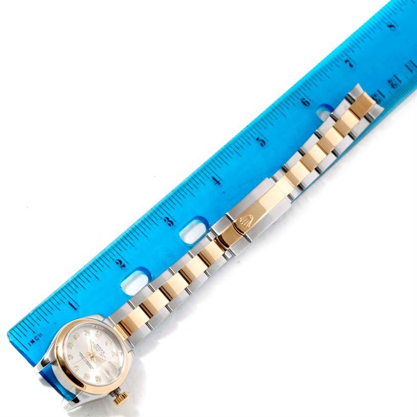 The image shows a Rolex Datejust 179163 Women's Steel and Gold (two tone) Silver Dial 179163 Women's Steel and Gold (two tone) Silver Dial watch laid flat beside a ruler, highlighting the watch face, bracelet, and clasp.