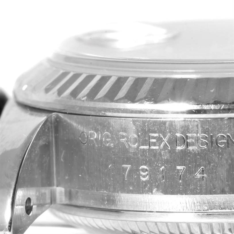 The image shows a close-up angle of the side of a Rolex Datejust 179174 Women's Stainless Steel Mother of Pearl Dial 179174 Women's Stainless Steel Mother of Pearl Dial watch, displaying the case and bezel with engravings.
