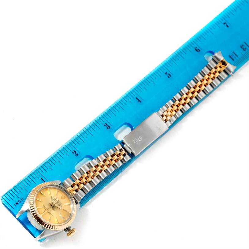 The Rolex Datejust 6917 Women's Stainless Steel Champagne Dial 6917 Women's Stainless Steel Champagne Dial watch is displayed flat with its face, bracelet, and clasp visible, measured alongside a blue ruler.
