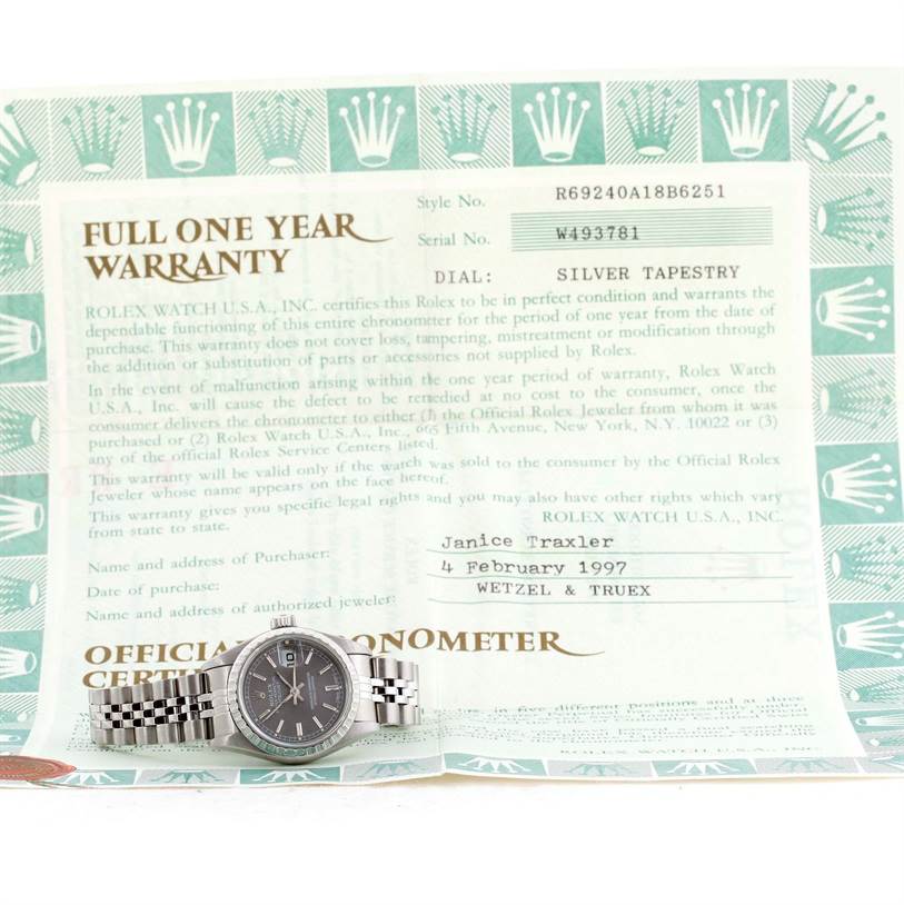 The image shows a Rolex Datejust 69240 Women's Stainless Steel Grey Dial 69240 Women's Stainless Steel Grey Dial watch and its warranty certificate, taken from a top-down angle.