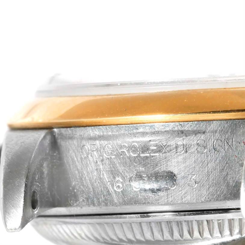 The image shows a close-up of the side of a Rolex Datejust 69163 Women's Stainless Steel White Dial 69163 Women's Stainless Steel White Dial watch case, featuring part of the bezel and engraved details.