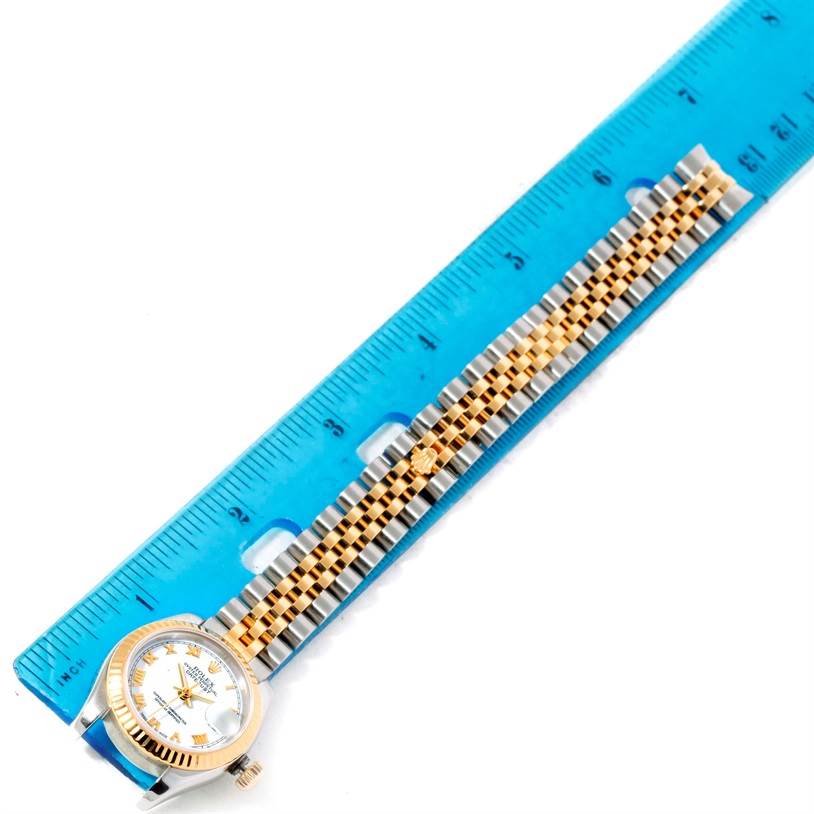 The image shows a Rolex Datejust 179173 Women's Steel and Gold (two tone) White Dial 179173 Women's Steel and Gold (two tone) White Dial watch, captured from a top-down angle, alongside a blue ruler for scale.