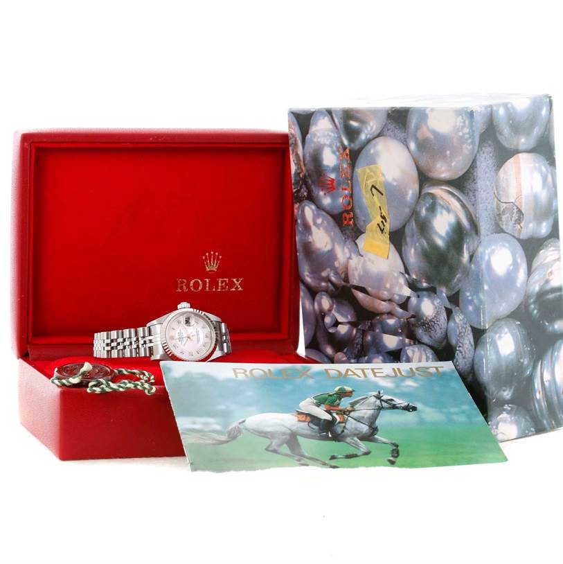 A Rolex Datejust 79174 Women's Stainless Steel Mother of Pearl Dial 79174 Women's Stainless Steel Mother of Pearl Dial watch is shown with its bracelet, alongside its red box, outer box, and a booklet.