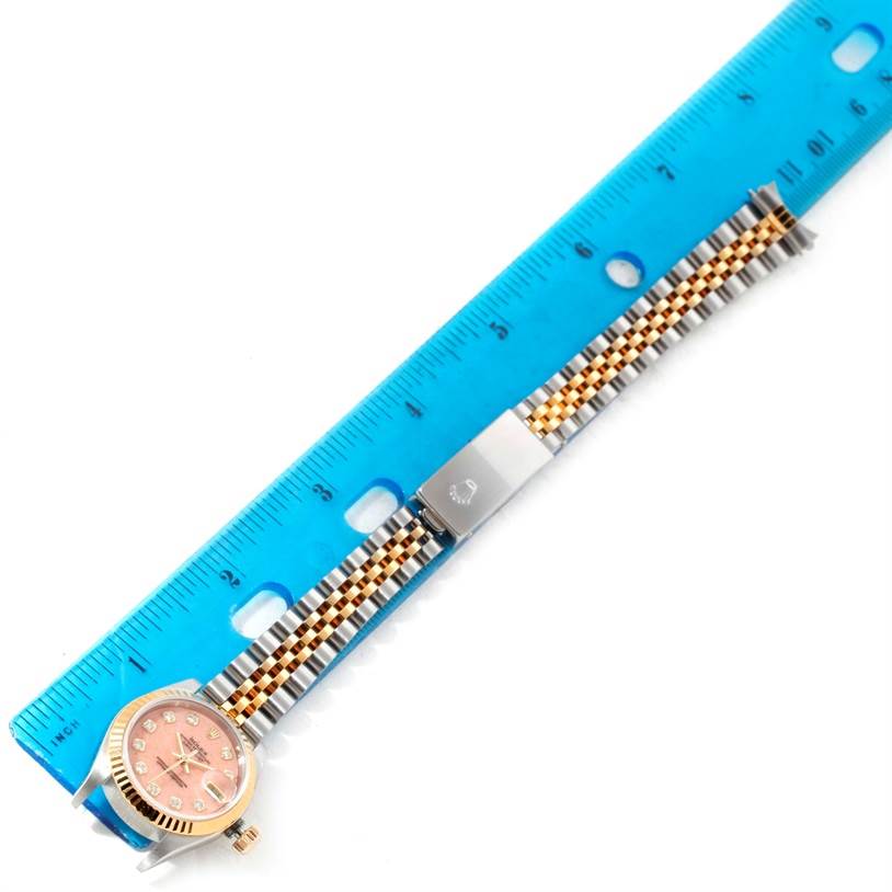 The image shows a Rolex Datejust 79163 Women's Steel and Gold (two tone) Pink Dial 79163 Women's Steel and Gold (two tone) Pink Dial watch with a pink dial and jubilee bracelet, measured against a blue ruler.