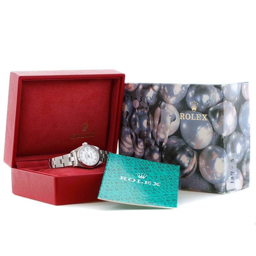 The image shows a Rolex Datejust 79174 Women's Stainless Steel White Dial 79174 Women's Stainless Steel White Dial watch positioned at an angle inside its red box, with the Rolex outer box and green paperwork nearby.