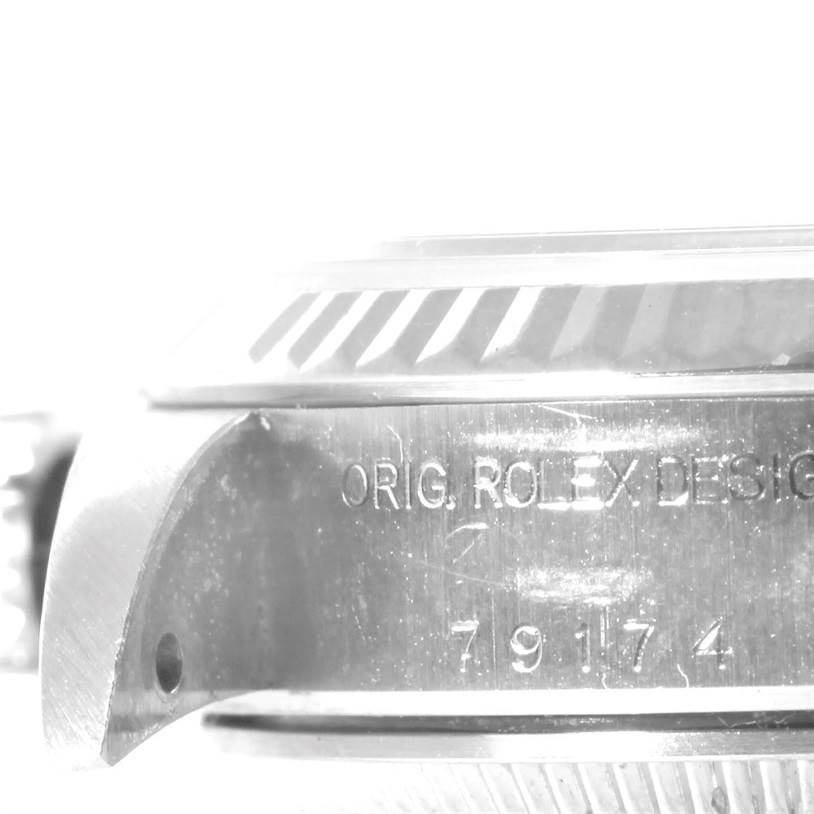 This image shows a close-up side view of the case back and the bezel of a Rolex Datejust 79174 Women's Stainless Steel White Dial 79174 Women's Stainless Steel White Dial model, displaying the engraved text.