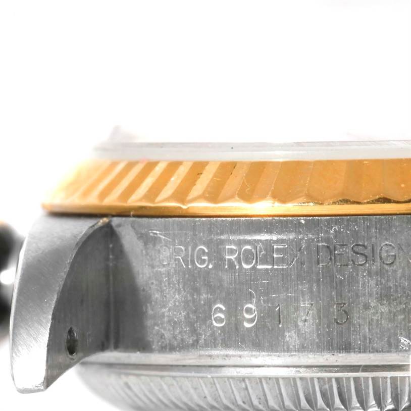 The image shows a close-up side view of a Rolex Datejust 69173 Women's Stainless Steel Champagne Dial 69173 Women's Stainless Steel Champagne Dial watch, focusing on the etched serial number, lugs, and fluted bezel.
