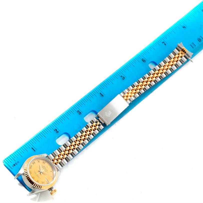 The image shows a Rolex Datejust 69173 Women's Stainless Steel Champagne Dial 69173 Women's Stainless Steel Champagne Dial watch with a two-tone jubilee bracelet placed alongside a blue ruler.