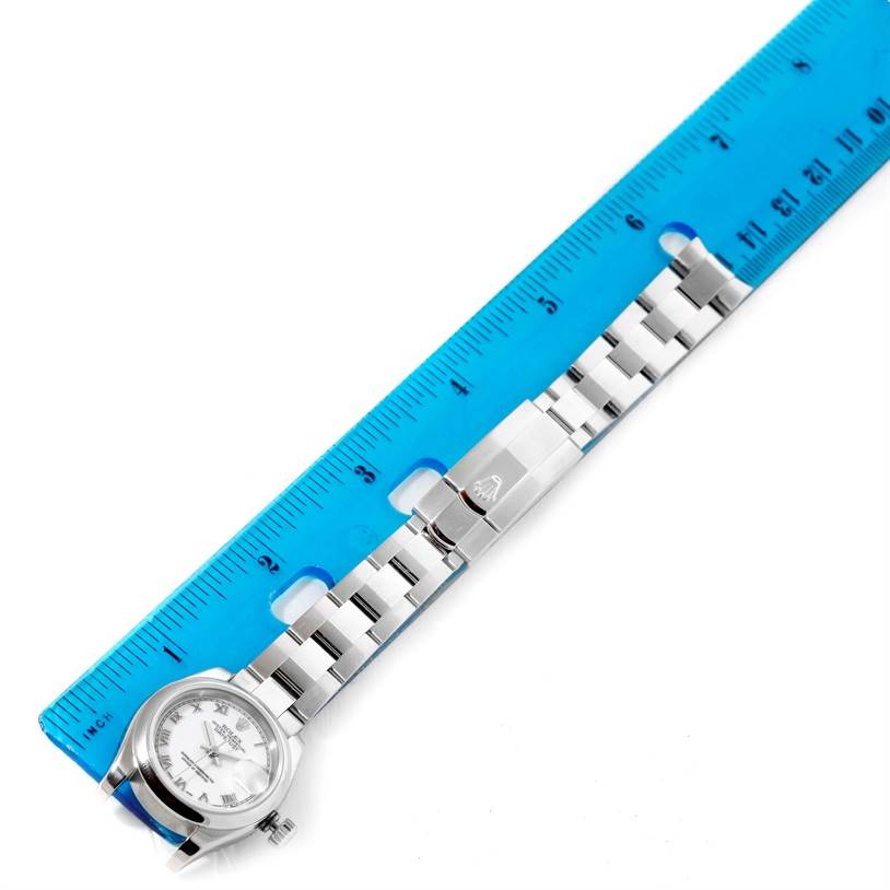 The image shows a top-down view of a Rolex Datejust 179160 Women's Stainless Steel White Dial 179160 Women's Stainless Steel White Dial watch, displaying the watch face, bracelet, and clasp, measured against a blue ruler.