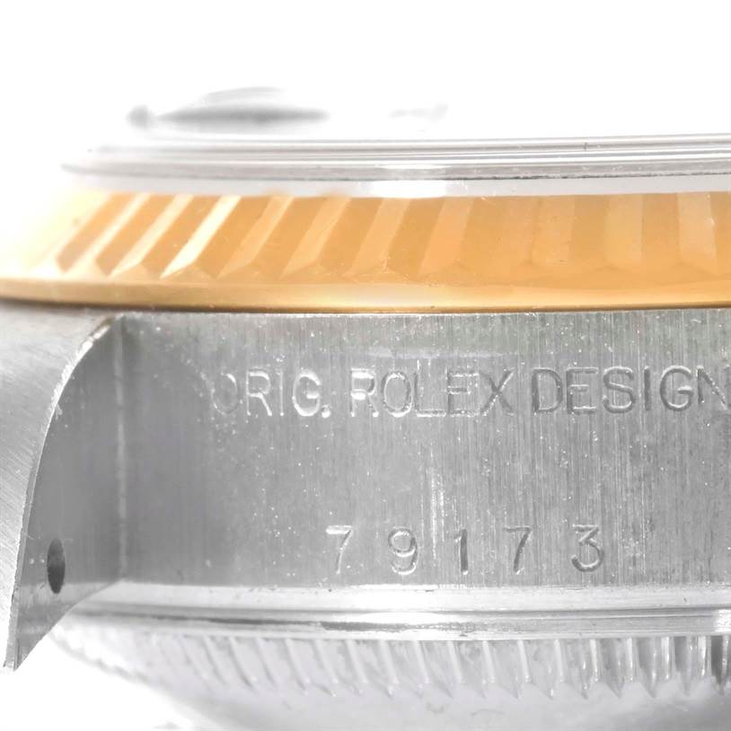 This image shows a close-up side view of the case and fluted bezel of a Rolex Datejust 79173 Women's Stainless Steel Blue Dial 79173 Women's Stainless Steel Blue Dial watch, with engraving visible.