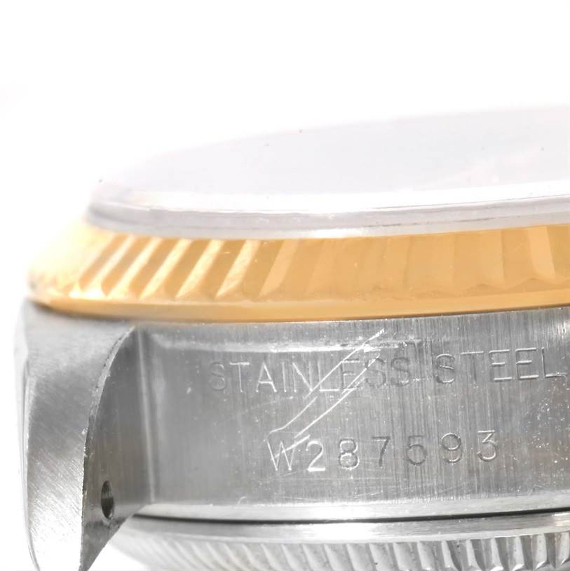 The image shows a close-up side angle of the Rolex Datejust 69173 Women's Stainless Steel Champagne Dial 69173 Women's Stainless Steel Champagne Dial watch, focusing on the bezel, crystal edge, and serial number engraving.