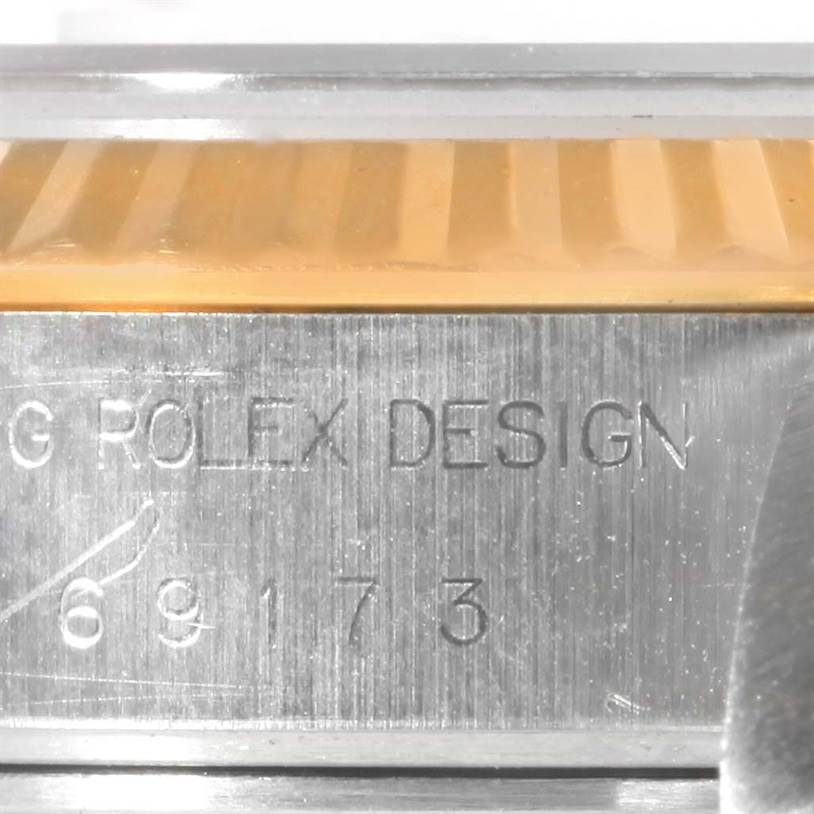 This image shows the serial number engraving and part of the fluted bezel on a Rolex Datejust 69173 Women's Stainless Steel Champagne Dial 69173 Women's Stainless Steel Champagne Dial model watch.