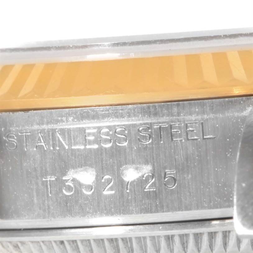 This image shows a close-up of the side of a Rolex Datejust 69173 Women's Stainless Steel Champagne Dial 69173 Women's Stainless Steel Champagne Dial model, focusing on the engraving "STAINLESS STEEL" and a portion of the bezel.