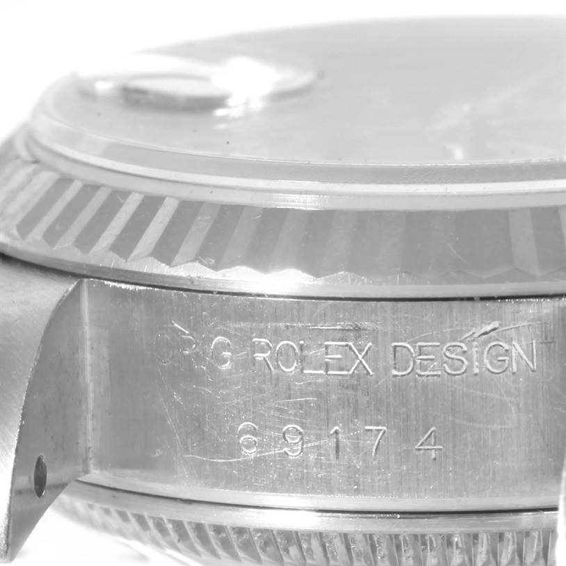This image shows a close-up of the side of a Rolex Datejust 69174 Women
s Stainless Steel Pink Dial 69174 Women
s Stainless Steel Pink Dial watch, focusing on the engravings and the bezel.