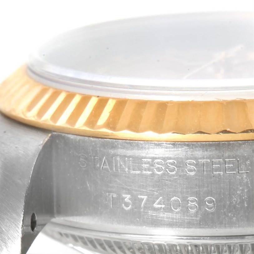 This image shows a close-up side angle of a Rolex Datejust 69173 Women's Stainless Steel Champagne Dial 69173 Women's Stainless Steel Champagne Dial watch case, bezel, and part of the crystal, with "STAINLESS STEEL" engraving.