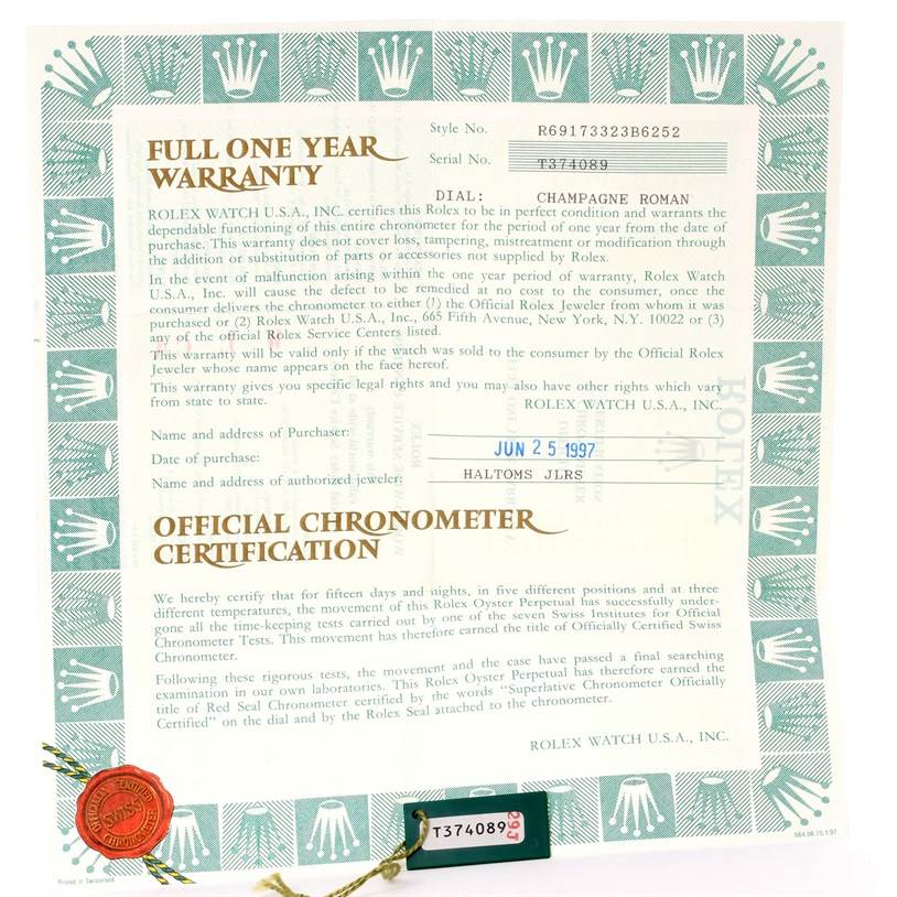 The image shows a full view of a Rolex Datejust 69173 Women's Stainless Steel Champagne Dial 69173 Women's Stainless Steel Champagne Dial warranty certificate with a serial number tag attached.