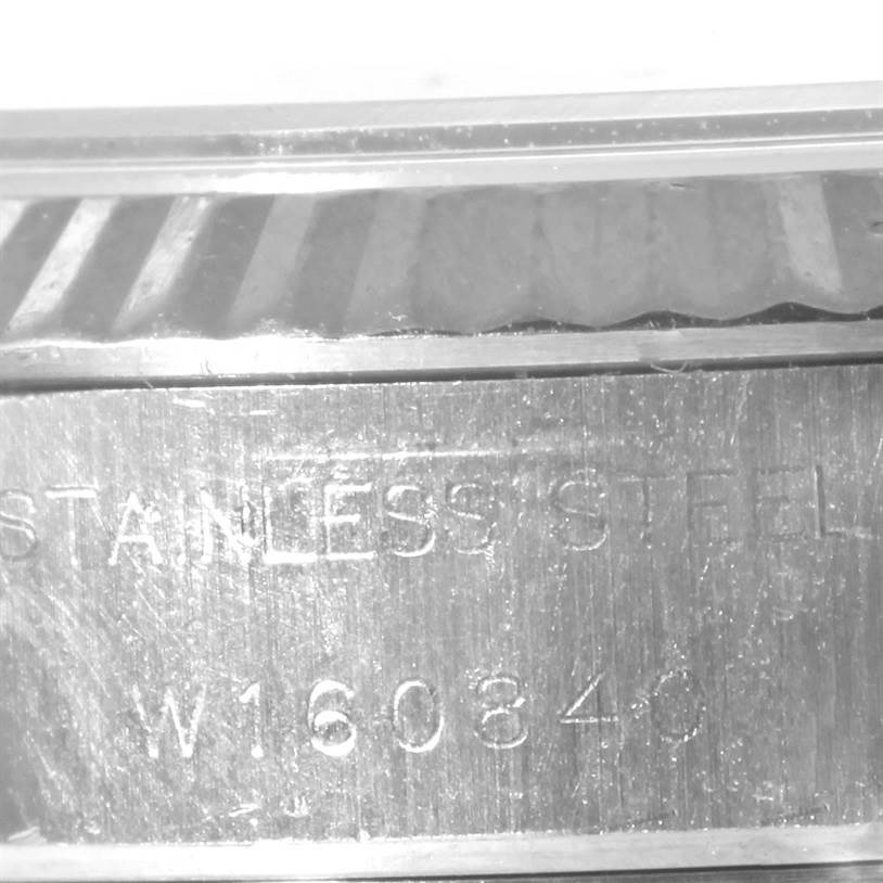 The image shows a close-up of the stainless steel case and fluted bezel with the serial number of a Rolex Datejust 69174 Women
s Stainless Steel Black Dial 69174 Women
s Stainless Steel Black Dial watch.