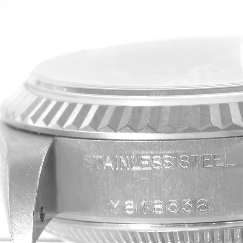 This image shows a close-up side view of a stainless steel case of a Rolex Datejust 79174 Women
s Stainless Steel Blue Dial 79174 Women
s Stainless Steel Blue Dial watch, highlighting the serial number and edge of the bezel.
