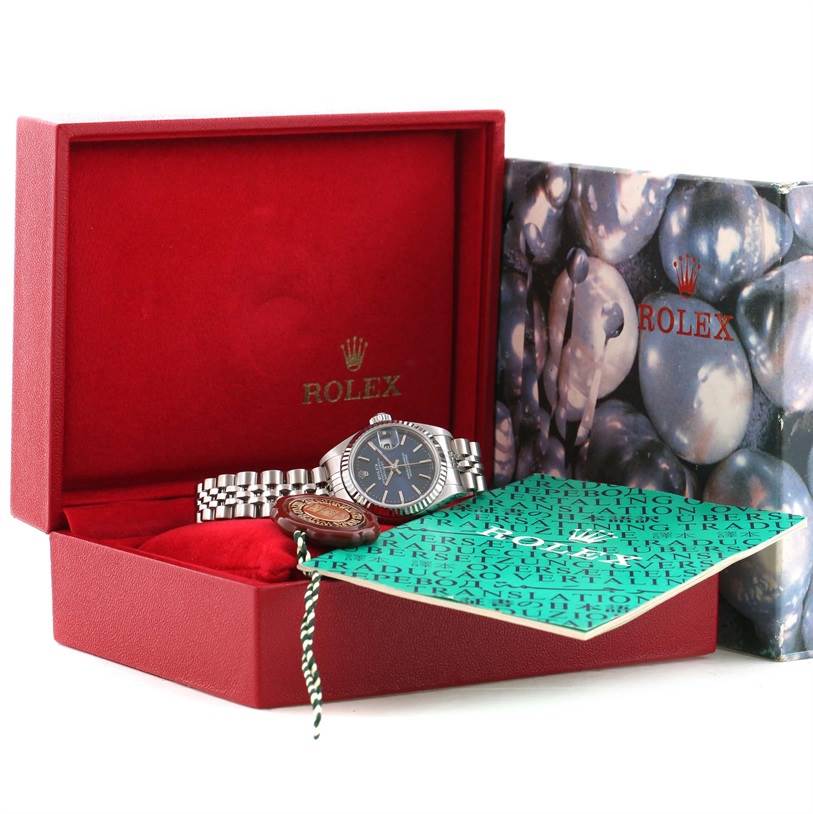 The Rolex Datejust 79174 Women
s Stainless Steel Blue Dial 79174 Women
s Stainless Steel Blue Dial watch is shown in an open red box, displaying the face, bracelet, and accompanying documents.