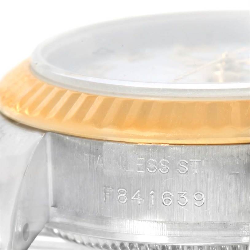 The image shows a close-up of the side and bezel of a Rolex Datejust 179173 Women's Steel and Gold (two tone) White Dial 179173 Women's Steel and Gold (two tone) White Dial watch, highlighting the serial number and stainless steel material.