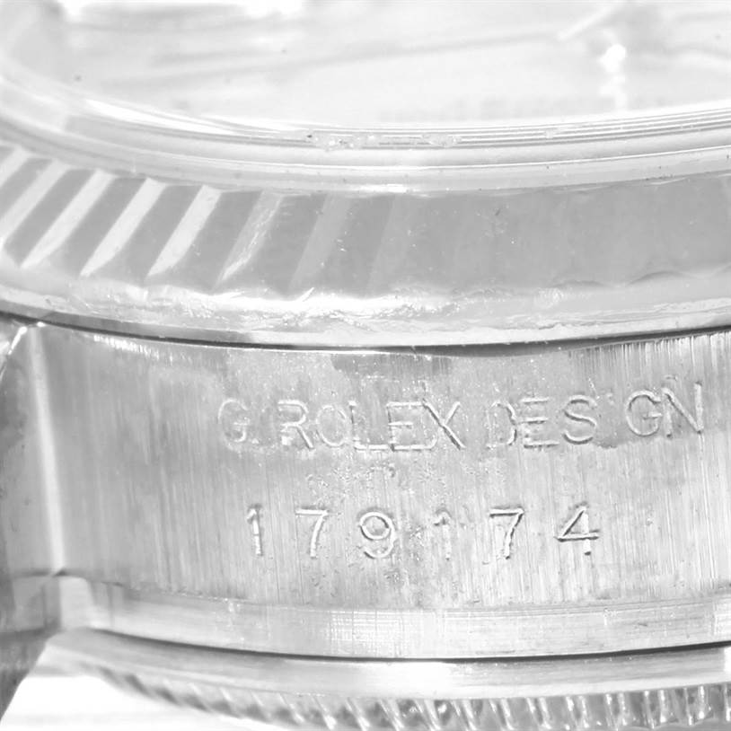 This is a close-up shot of a Rolex Datejust 179174 Women
s Stainless Steel Mother of Pearl Dial 179174 Women
s Stainless Steel Mother of Pearl Dial showing the engraved model number and part of the fluted bezel.