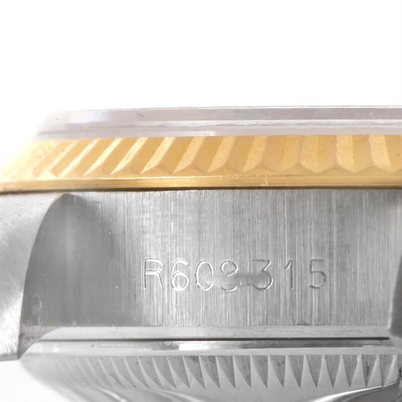 This image shows the side view of the case of a Rolex Datejust 69173 Women's Stainless Steel Mother of Pearl Dial 69173 Women's Stainless Steel Mother of Pearl Dial watch, displaying the serial number and part of the fluted bezel.