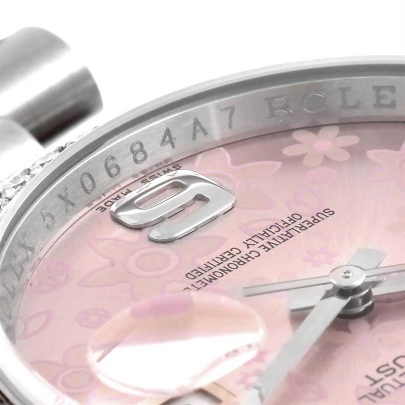 This close-up image of a Rolex Datejust 116244PFAO Women's Stainless Steel Pink Dial 116244PFAO Women's Stainless Steel Pink Dial watch shows the serial number engraving, partial pink floral dial, hands, and date window.