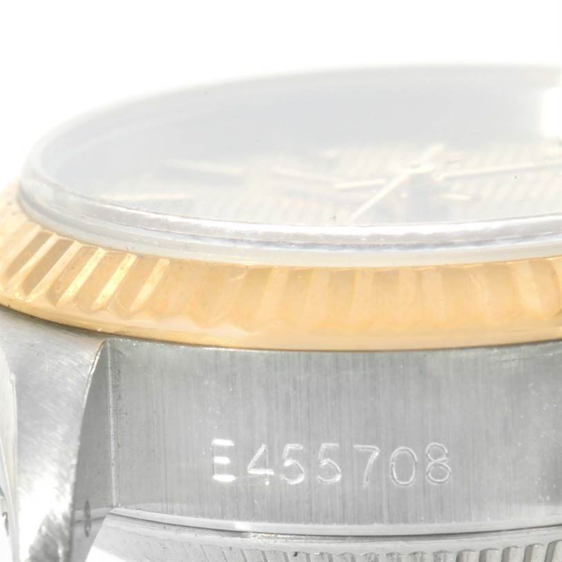 The image shows a close-up side view of the Rolex Datejust 69173 Women's Stainless Steel Champagne Dial 69173 Women's Stainless Steel Champagne Dial, displaying the bezel and part of the case with serial number.