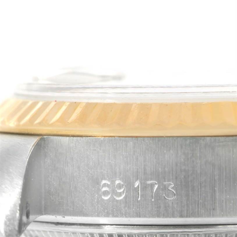 This image shows a close-up of the side of a Rolex Datejust 69173 Women's Stainless Steel Champagne Dial 69173 Women's Stainless Steel Champagne Dial watch case, focusing on the bezel and part of the serial number.