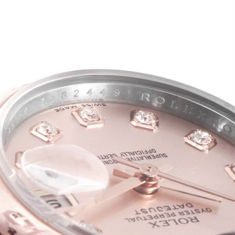 The image shows a close-up angle of the dial and bezel of a Rolex Datejust 179161PDO Women's Steel and Gold (two tone) Pink Dial 179161PDO Women's Steel and Gold (two tone) Pink Dial watch, highlighting the date magnifier and diamond markers.