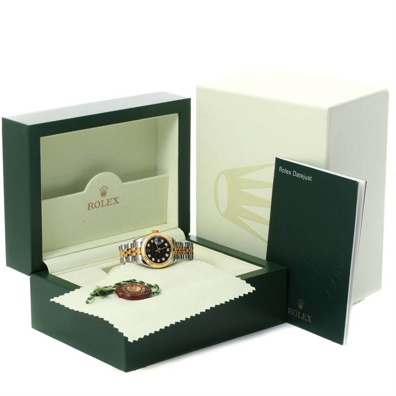 The image shows a Rolex Datejust 179173 Women's Steel and Gold (two tone) Black Dial 179173 Women's Steel and Gold (two tone) Black Dial watch at an angle, in its open box with a manual and accessories.