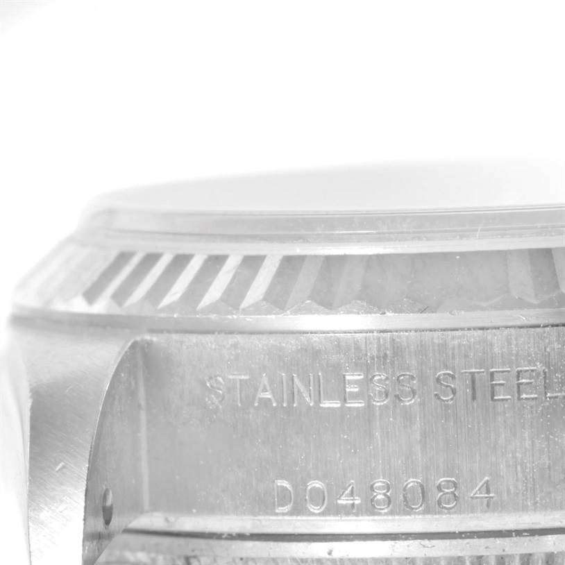 The image shows a close-up of the case side and part of the fluted bezel of a Rolex Datejust 79174 Women's Stainless Steel Pink Dial 79174 Women's Stainless Steel Pink Dial watch, highlighting its stainless steel material and serial number.