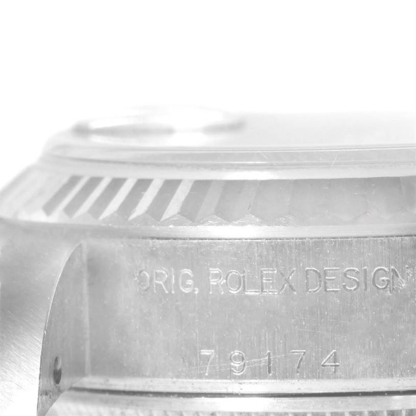 This image shows a close-up of the side of a Rolex Datejust 79174 Women's Stainless Steel Pink Dial 79174 Women's Stainless Steel Pink Dial watch, highlighting the engravings and the fluted bezel.