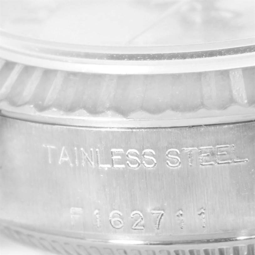 This image shows a partial side view of the stainless steel case and fluted bezel of a Rolex Datejust 79174 Women
s Stainless Steel Silver Dial 79174 Women
s Stainless Steel Silver Dial watch with the model number 162711 engraved.