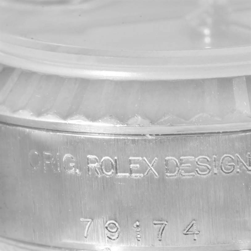 The image shows a close-up of the side case of a Rolex Datejust 79174 Women
s Stainless Steel Silver Dial 79174 Women
s Stainless Steel Silver Dial watch, featuring the "ORIG. ROLEX DESIGN" inscription and part of the bezel.