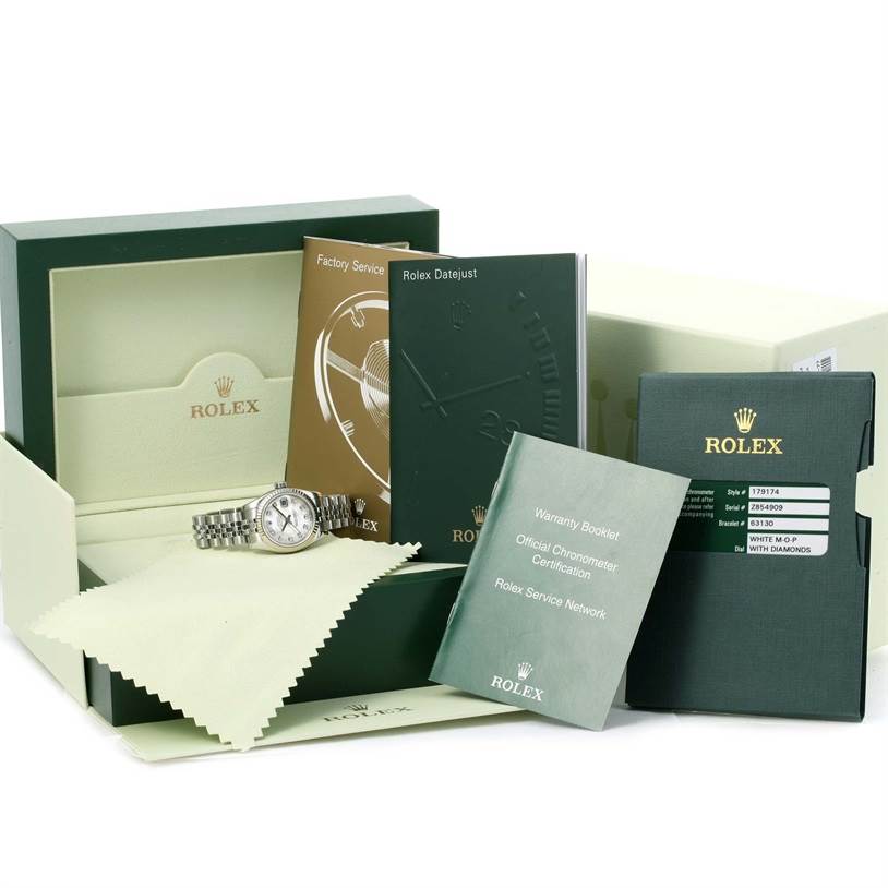 The image shows a Rolex Datejust 179174 Women
s Stainless Steel Mother of Pearl Dial 179174 Women
s Stainless Steel Mother of Pearl Dial watch laid flat, accompanied by booklets, a warranty card, and its presentation box.