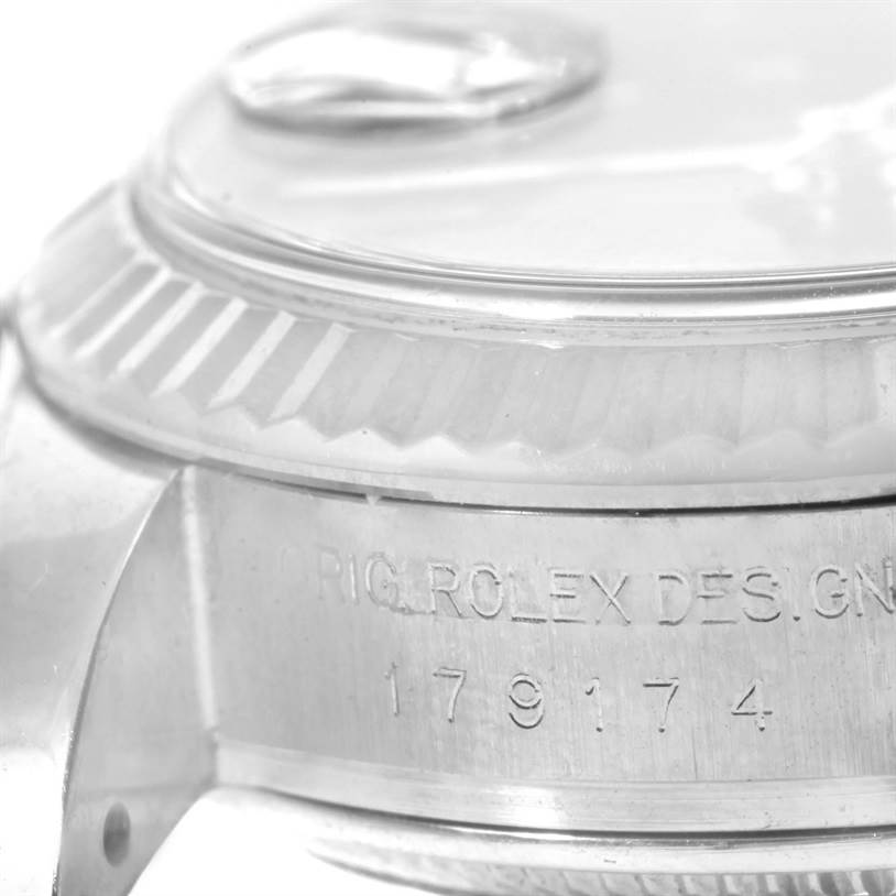 This close-up image of a Rolex Datejust 179174 Women's Stainless Steel Black Dial 179174 Women's Stainless Steel Black Dial watch focuses on the side casing with part of the bezel and the serial number.