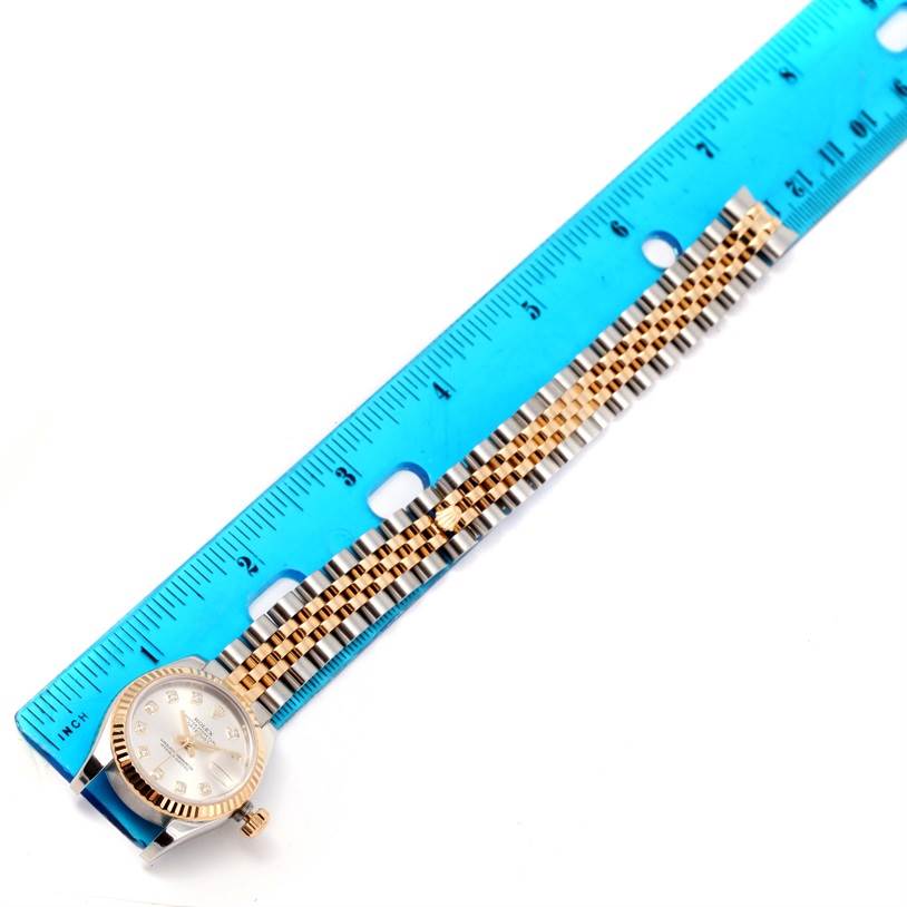 The Rolex Datejust 179173 Women's Steel and Gold (two tone) Silver Dial 179173 Women's Steel and Gold (two tone) Silver Dial watch is shown from an overhead angle, with the watch face and full bracelet clearly visible beside a ruler.