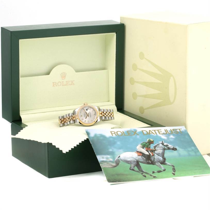 This image shows a Rolex Datejust 179173 Women's Steel and Gold (two tone) Silver Dial 179173 Women's Steel and Gold (two tone) Silver Dial model watch in its open box, with a brochure beside it.
