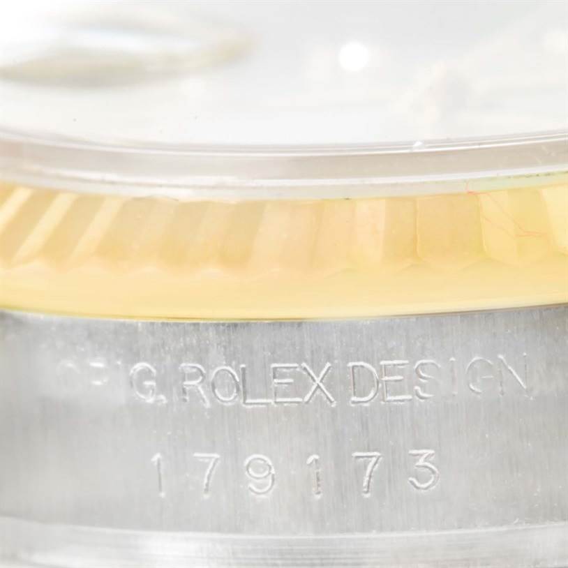 This image shows a close-up view of the bezel and case side of a Rolex Datejust 179173 Women's Steel and Gold (two tone) Mother of Pearl Dial 179173 Women's Steel and Gold (two tone) Mother of Pearl Dial watch, including its serial number.