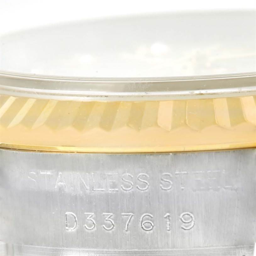 This image shows a close-up of the side view of a Rolex Datejust 179173 Women's Steel and Gold (two tone) Mother of Pearl Dial 179173 Women's Steel and Gold (two tone) Mother of Pearl Dial watch, highlighting the stainless steel part with a serial number and the gold bezel.