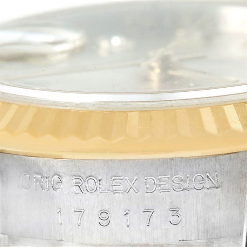 The image shows a close-up side profile of a Rolex Datejust 179173SDO Women's Steel and Gold (two tone) Silver Dial 179173SDO Women's Steel and Gold (two tone) Silver Dial watch, focusing on the bezel and engraved model number.