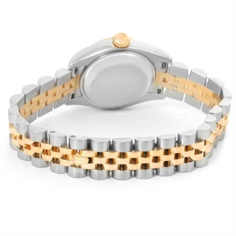 The image shows the back of a Rolex Datejust 179173 Women's Steel and Gold (two tone) Mother of Pearl Dial 179173 Women's Steel and Gold (two tone) Mother of Pearl Dial watch, highlighting its two-tone metal bracelet and gold crown at the top.