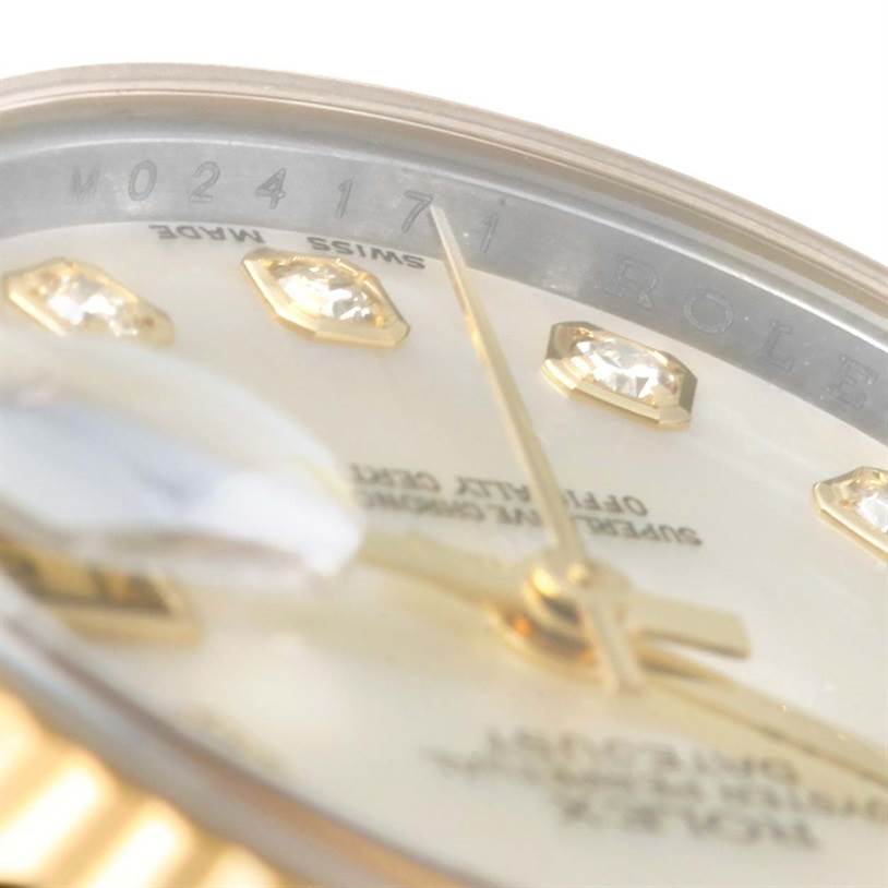 This close-up angle of the Rolex Datejust 179173 Women's Steel and Gold (two tone) Mother of Pearl Dial 179173 Women's Steel and Gold (two tone) Mother of Pearl Dial watch shows part of the dial, diamond markers, hands, and part of the rehaut with text.
