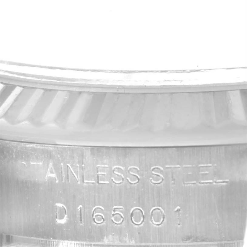 This image shows a close-up of the case side of a Rolex Datejust 179174 Women's Stainless Steel White Dial 179174 Women's Stainless Steel White Dial watch, highlighting the stainless steel text and part of the fluted bezel.