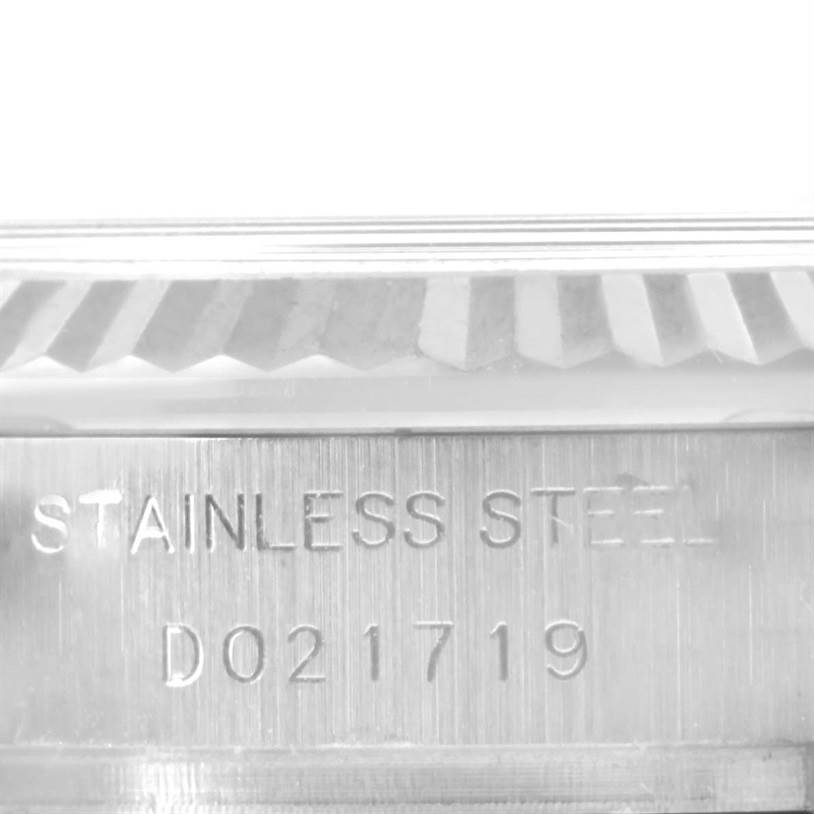 The image shows a close-up view of the case side and fluted bezel of a Rolex Datejust 179174 Women
s Stainless Steel Black Dial 179174 Women
s Stainless Steel Black Dial, highlighting the stainless steel stamp and serial number.