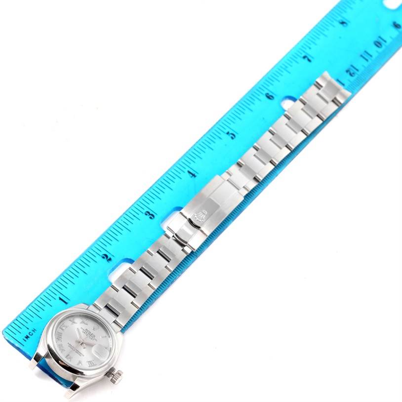 The Rolex Datejust 179160 Women's Stainless Steel Grey Dial 179160 Women's Stainless Steel Grey Dial watch is shown flat with its entire length measured against a blue ruler.