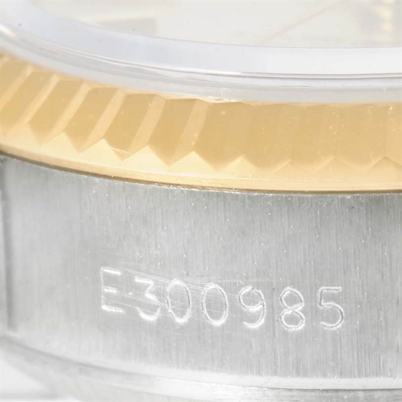 This close-up image of the Rolex Datejust 69173 Women
s Stainless Steel Silver Dial 69173 Women
s Stainless Steel Silver Dial model shows the engraved serial number on the stainless steel case and the gold fluted bezel.