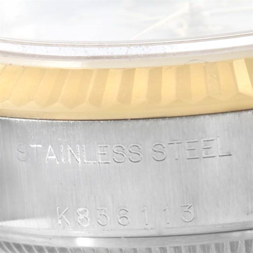 This close-up image of a Rolex Datejust 79173 Women's Stainless Steel Beige Dial 79173 Women's Stainless Steel Beige Dial watch shows part of the stainless steel case and the fluted bezel.