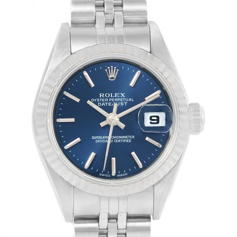 The image shows a front view of a Rolex Datejust watch, highlighting its blue dial, fluted bezel, and metal bracelet.